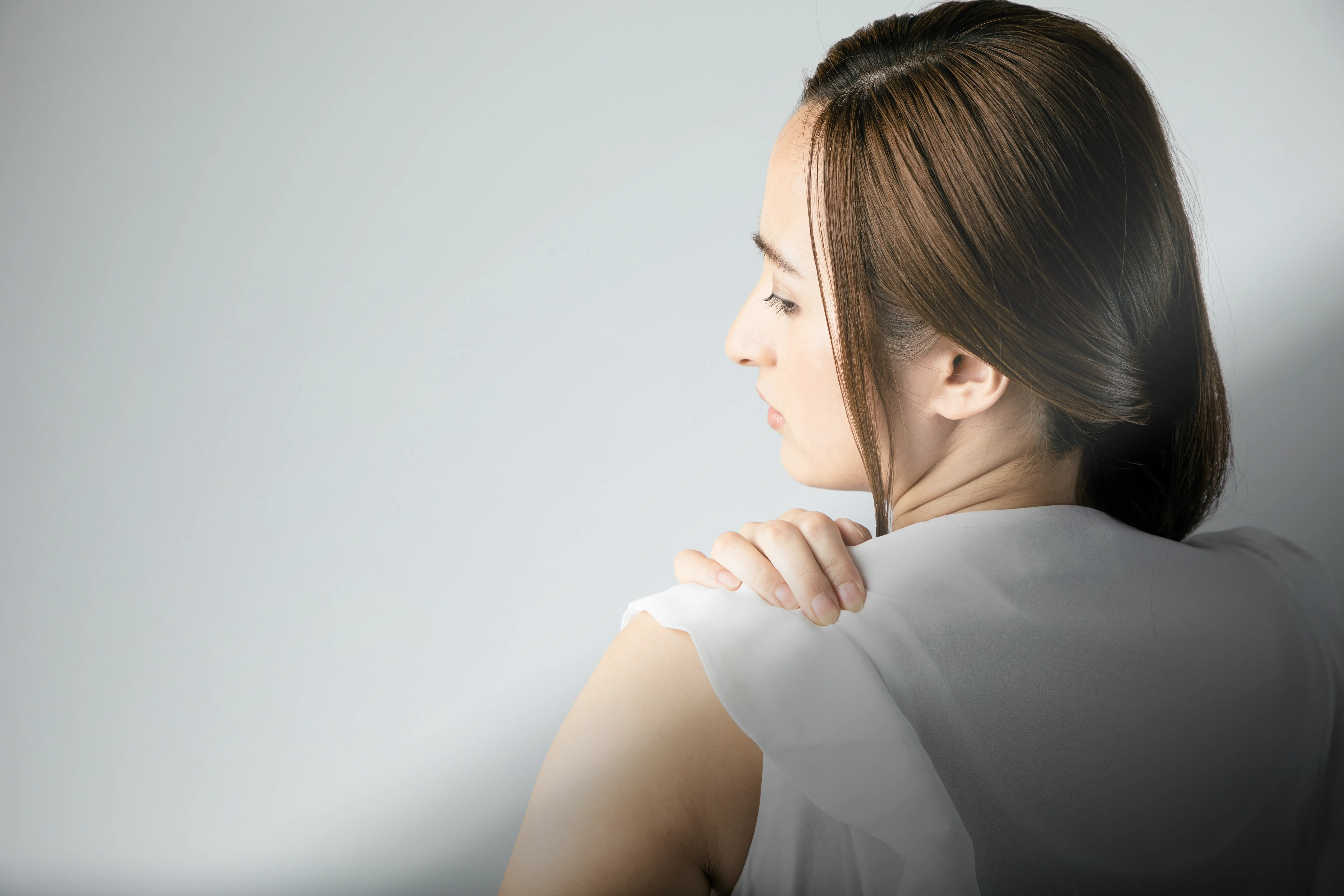 女性が肩の痛みで困っている様子